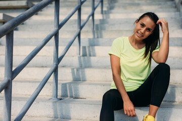 Beautiful lady resting between exercises on fresh air