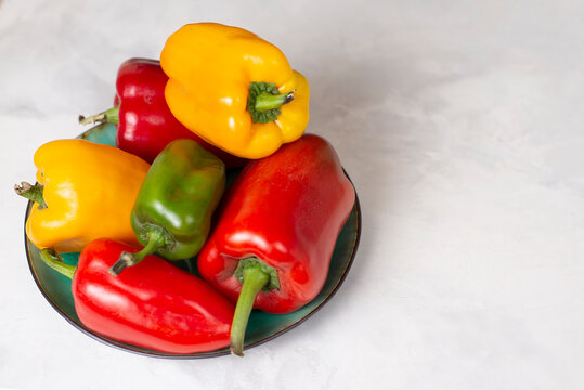 Bright juicy fresh sweet bell peppers of red, yellow and green color on a white background. Still life food. Copy space
