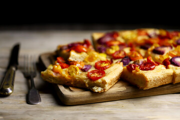 Selective focus. Macro. Fresh homemade focaccia with tomatoes and blue onions. Italian cuisine at...