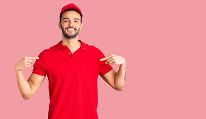 Young handsome hispanic man wearing delivery courier uniform looking confident with smile on face,...