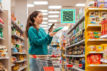 A young beautiful Caucasian woman reads the qr code information using her smartphone. QR-code icon above the product. The concept of purchasing products and mobile apps.