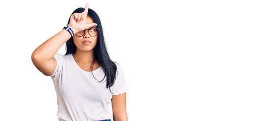 Young beautiful asian girl wearing casual clothes and glasses making fun of people with fingers on...
