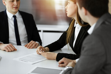 Fototapeta premium Businessman and woman with colleague sitting and working at the desk. Business people discussing questions at meeting in sunny office