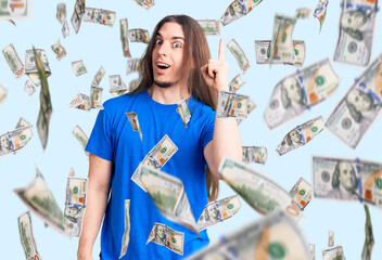 Young adult man with long hair wearing swimwear pointing finger up with successful idea. exited and...