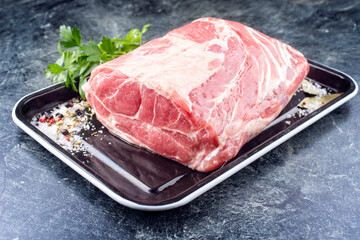 Modern style traditional raw corned pot pork roast with herbs offer offered as close-up on a rustic metal tray