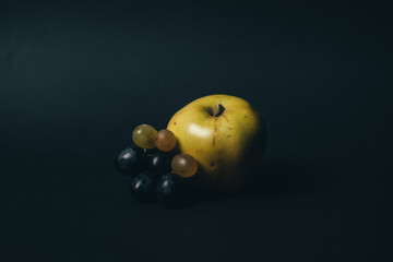 autumn golden apple and grapes on black background. High quality photo