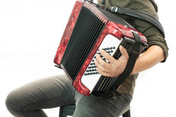 Closeup detail of a man in a black shirt playing the red accordion Hand close-up