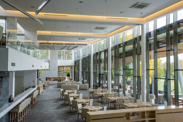 Interior of modern luxurious with two rows of tables and white couches for rest