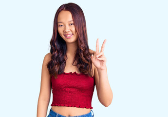 Young beautiful chinese girl wearing casual clothes showing and pointing up with fingers number two while smiling confident and happy.