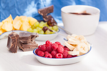 Fondue with melted chocolate, fruits and berries.