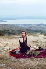 young woman lies in nature in a black dress