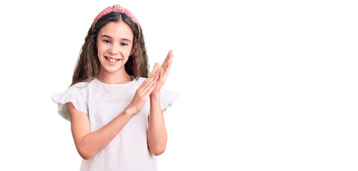 Cute hispanic child girl wearing casual white tshirt clapping and applauding happy and joyful,...