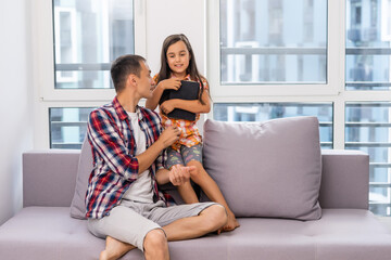 a young father with his little daughter reads the Bible