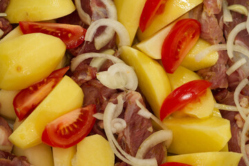 pork meat, potatoes, tomatoes and onions, ready to bake