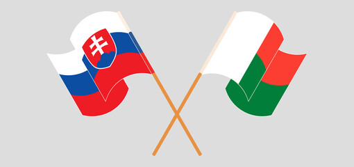 Crossed and waving flags of Madagascar and Slovakia