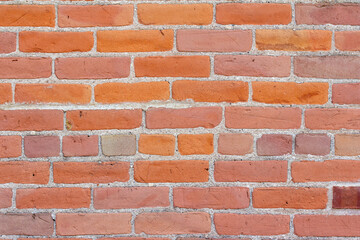 Close up full frame abstract background of an antique orange and pink weathered brick wall texture, with grunge textured surface showing wear and some deterioration