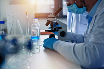 Fototapeta premium Doctor in the laboratory analyzes samples under a microscope. Pharmaceutical treatment concept.