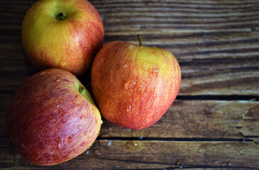 Close up and overhead view, red and yellow apples with drops of water, on rustic wood