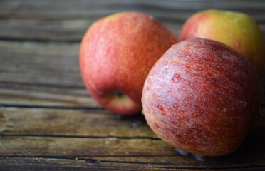 Close up, red apple with water drops on rustic wooden boards
