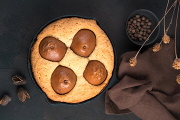 Homemade pie with pears on a brown background. The concept of home baking, festive backgrounds.