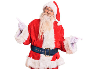 Old senior man with grey hair and long beard wearing traditional santa claus costume smiling confident pointing with fingers to different directions. copy space for advertisement