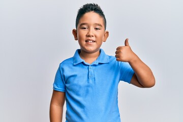 Little boy hispanic kid wearing casual clothes smiling happy and positive, thumb up doing excellent and approval sign