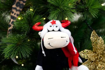 toy bull in a white hat with a red star hangs on an tree