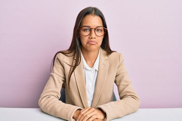 Beautiful hispanic woman working at the office depressed and worry for distress, crying angry and afraid. sad expression.