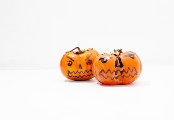 Jack - o ' - lantern, Halloween monsters - muzzles drawn on persimmon fruit. Persimmon is very similar to a pumpkin, the same orange and cheerful.