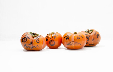 Jack - o ' - lantern, Halloween monsters - muzzles drawn on persimmon fruit. Persimmon is very similar to a pumpkin, the same orange and cheerful.