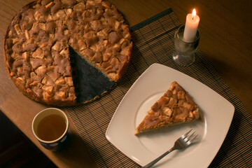 Tarta de manzana con vela y taza de té - ideal para actividades de otoño - horizontal