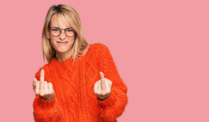 Beautiful blonde woman wearing casual clothes and glasses showing middle finger doing fuck you bad...