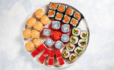 Obraz na płótnie Canvas rolls and sushi on a blue sky bright light background top view