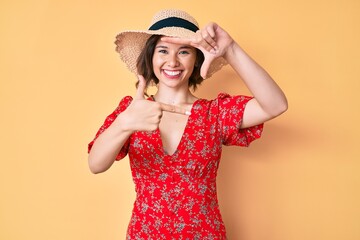 Young beautiful girl wearing summer hat smiling making frame with hands and fingers with happy face. creativity and photography concept.