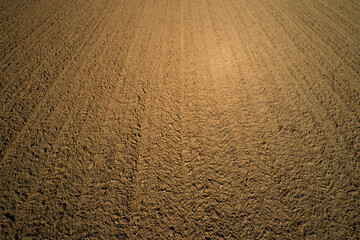 Earth top view. Brown plowed field. Brown background on the field aerial view.