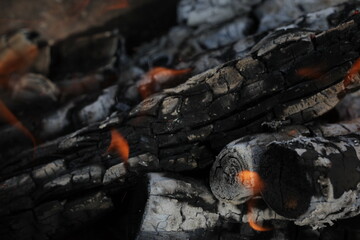 Smoldered logs burned in vivid fire close up. Atmospheric background with flame of campfire....
