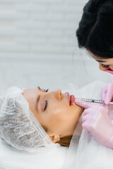 Cosmetology procedure for lip augmentation and wrinkle removal for a young beautiful girl....
