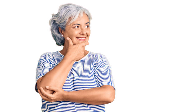 Senior woman with gray hair wearing casual striped clothes with hand on chin thinking about question, pensive expression. smiling with thoughtful face. doubt concept.