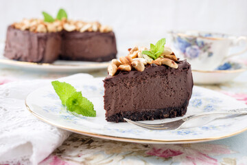 Traditional chocolate pie with cashew nuts offered as close-up on a design bone China plate