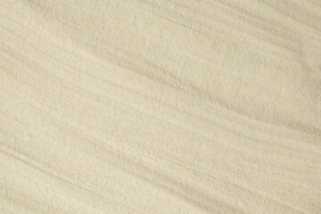 Fototapeta na wymiar A background of fine quartz sand, laid with soft waves. Template.