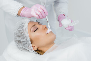 Moisturizing the lips during a cosmetic procedure for a young girl. Cosmetology