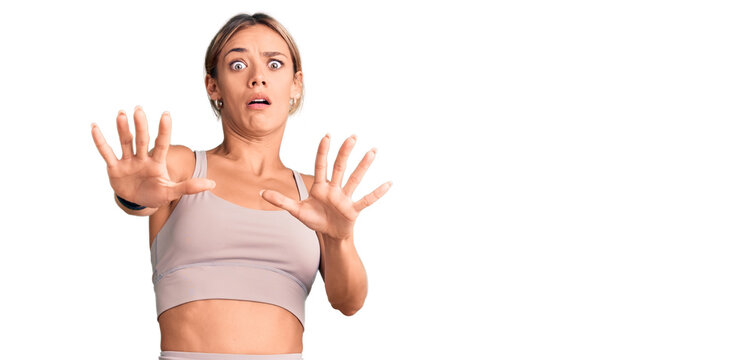 Beautiful caucasian woman wearing sportswear doing stop gesture with hands palms, angry and frustration expression