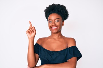 Young african american woman wearing casual clothes with a big smile on face, pointing with hand and finger to the side looking at the camera.