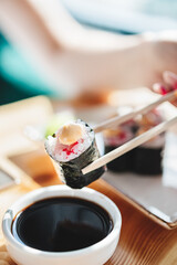 sushi rolls with seafood on the table sticks in hand