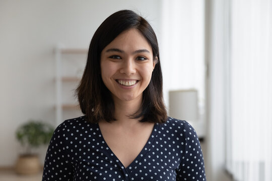 Profile picture of smiling young Vietnamese woman show optimism leadership. Close up headshot portrait of happy millennial asian 20s female renter or tenant pose look at camera in own flat apartment.