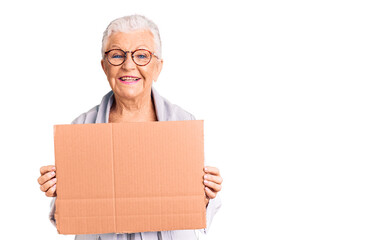 Senior beautiful woman with blue eyes and grey hair holding we need a change banner looking positive and happy standing and smiling with a confident smile showing teeth