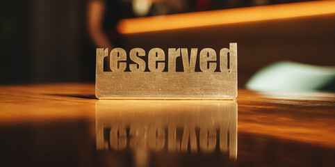 metal sign reserved on a wooden table in a cafe