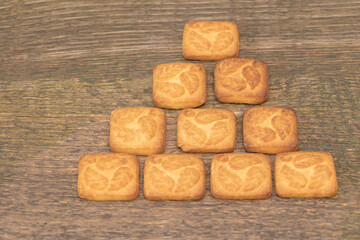 A few biscuits on a wooden background in the shape of a pyramid