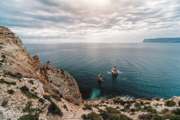 Autumn sea landscape with overcast sky and volcanic rocky coastline. Calm sea on a background of...