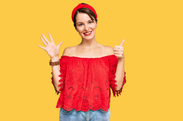 Fototapeta na wymiar Young brunette woman with short hair wearing casual summer clothes and diadem showing and pointing up with fingers number six while smiling confident and happy.